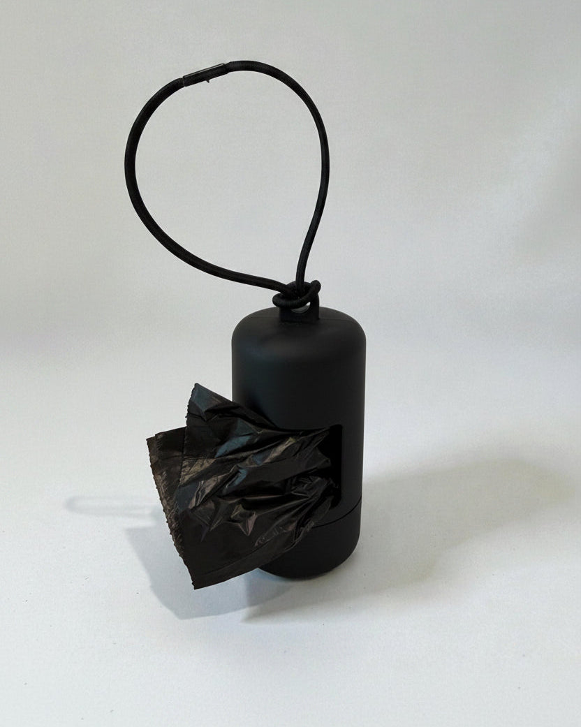 Black plastic bag holder with a black plastic bag on a white background