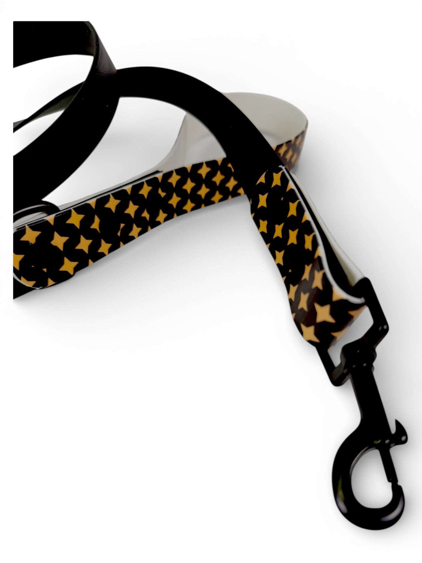Dog leash with black and gold star pattern on a white background