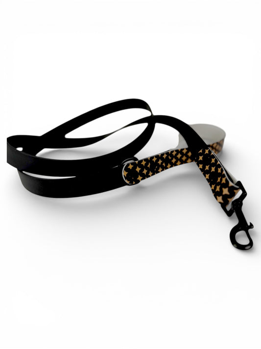 Dog leash with black and gold star  pattern on a white background
