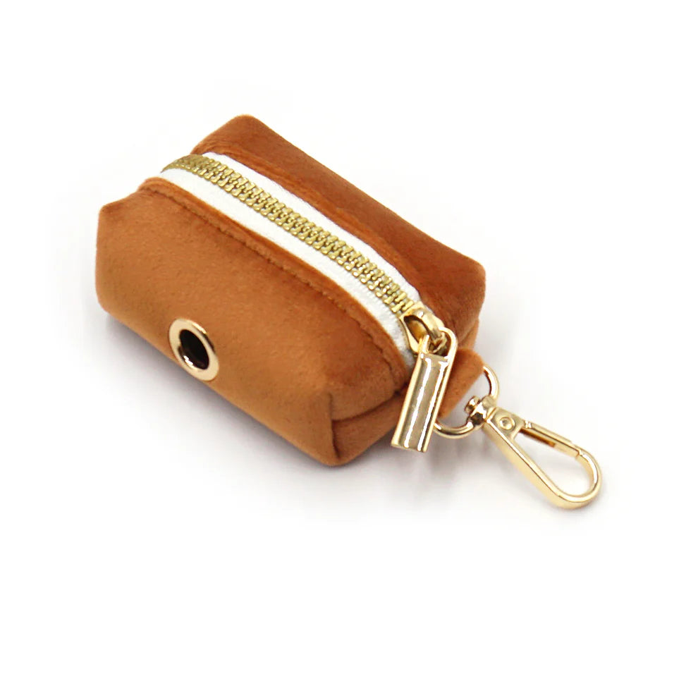 Brown velvet poop bag dispenser with gold zipper and clasp on a white background